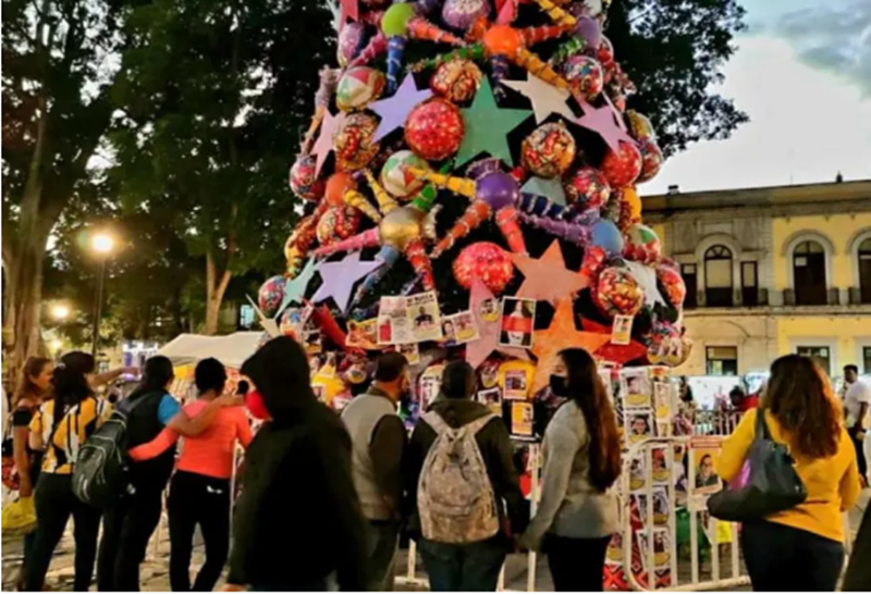 En Oaxaca adornan árbol de navidad con fotos de padres deudores