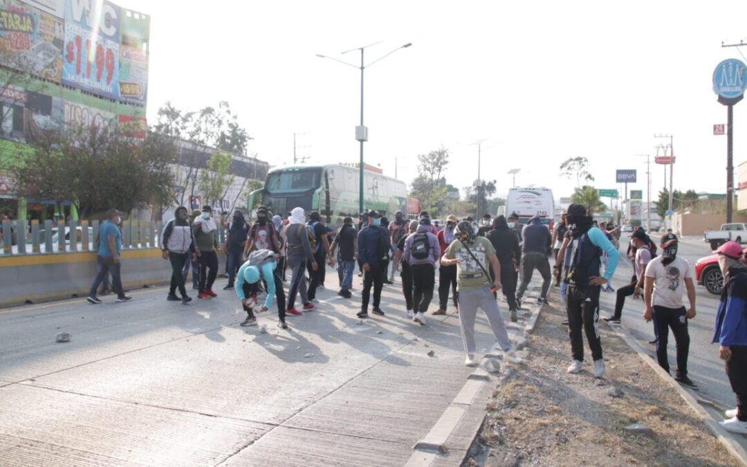 Chocan normalistas de Ayotzinapa con policías antimotines en Autopista del Sol